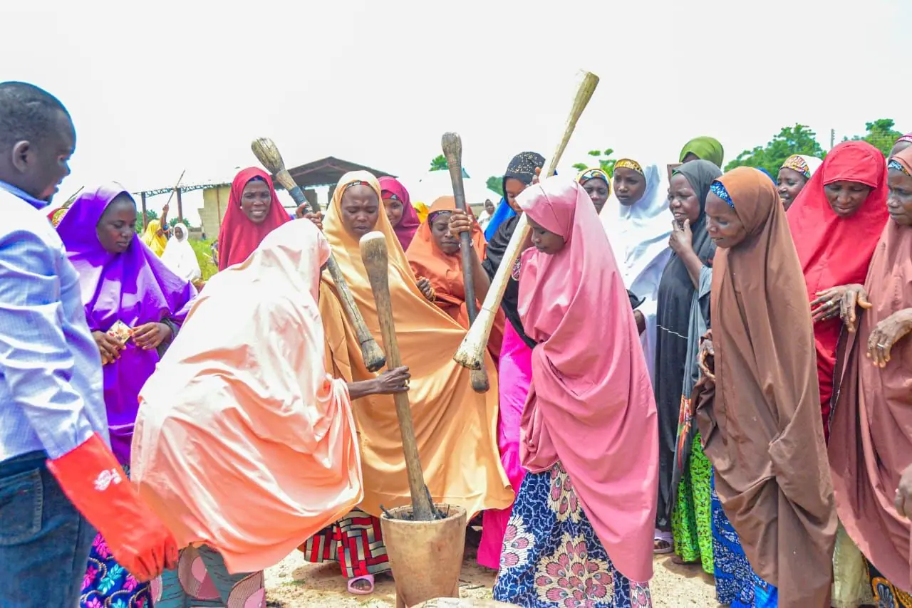 Women pounding biomass with mortar and pestle during a Biochar Solutions Africa training session