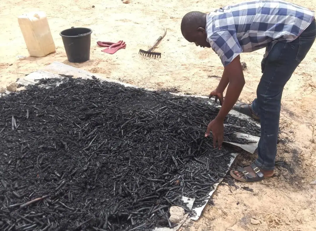 Freshly pyrolysed biochar raked out to dry on sheeting at the production site
